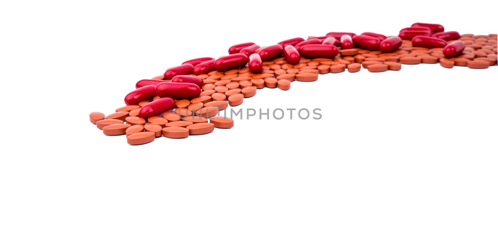 Red vitamins and supplements capsule and iron tablets isolated on white background with copy space and clipping path. Use for topics content about treatment anemia in adult and elderly people by Fahroni