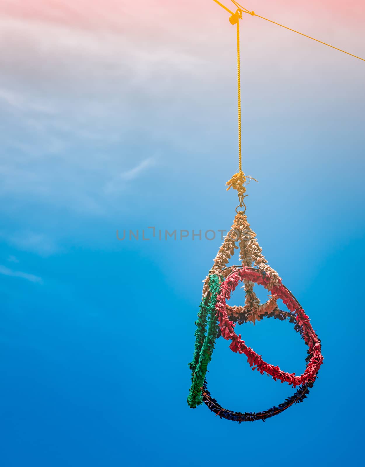 Red, green, blue, yellow loop for sepak takraw game on blue sky background with sunshine by Fahroni