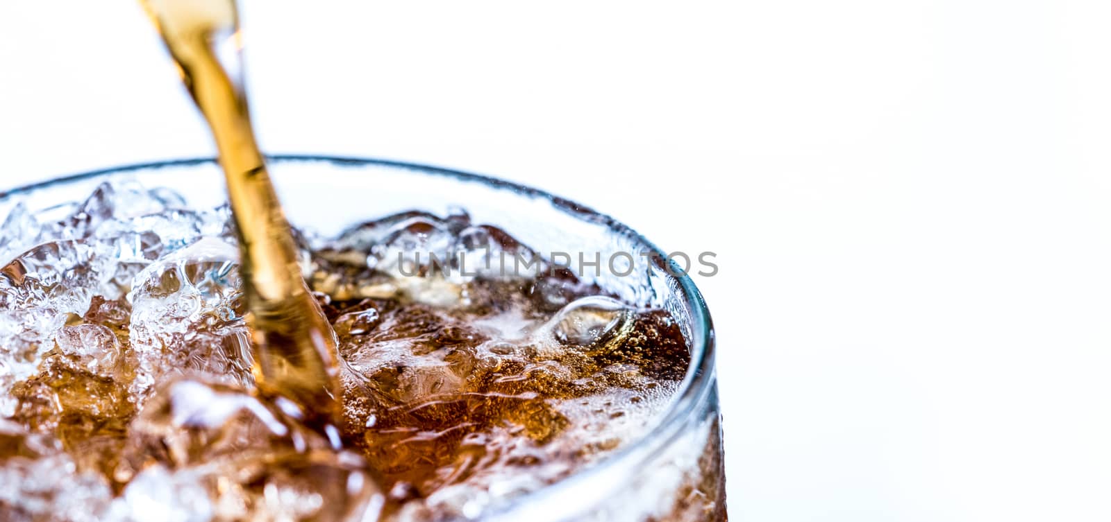 Closeup of soft drink pouring to glass with ice isolated on white background with copy space. by Fahroni