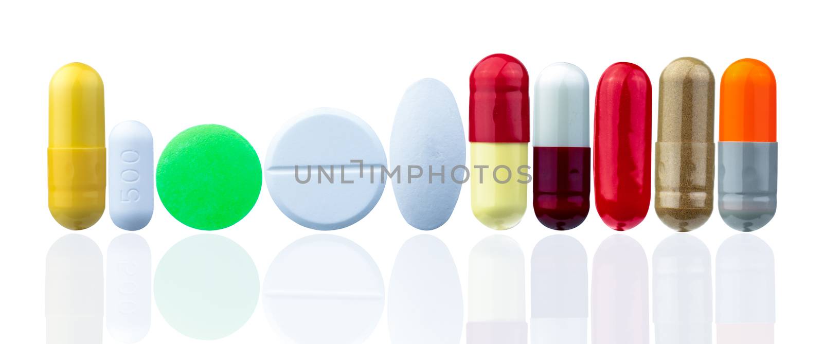 Different size and shape of pill isolated on white background with beautiful pattern. Yellow, green, white, red, orange, gold, and grey tablets and capsules medicine. Colorful drug. Healthcare concept