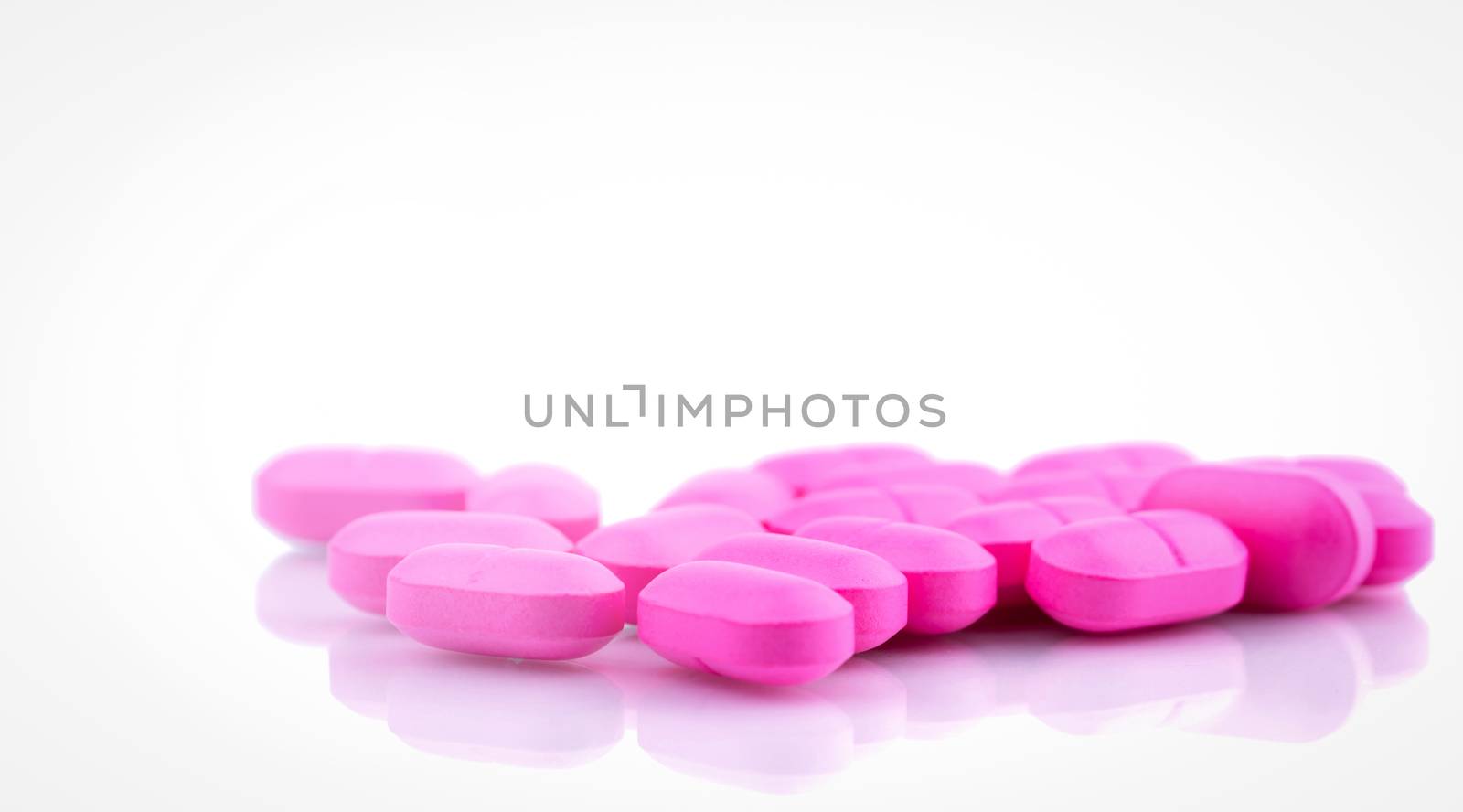 Pile of pink tablets pill isolated on white background. Norfloxacin 400 mg for treatment cystitis. Antibiotics drug resistance. Pharmaceutical industry. Pharmacy background. Global healthcare.