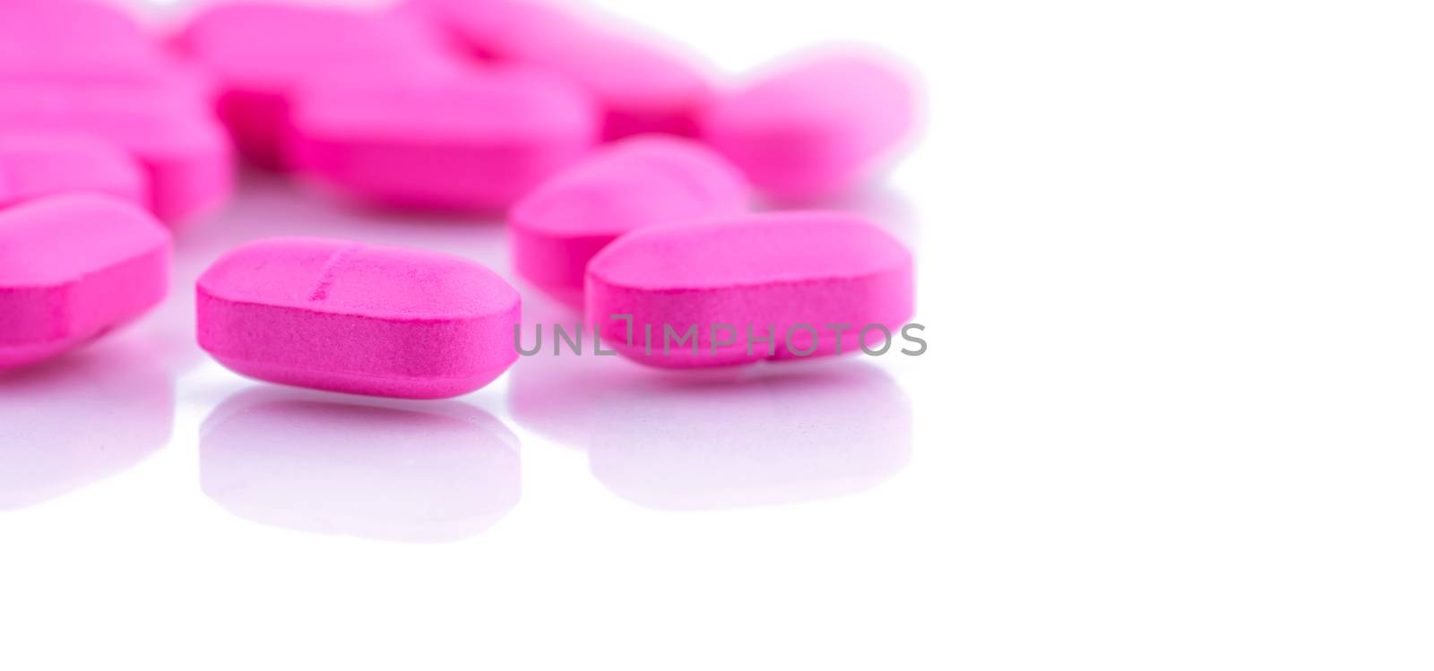 Pile of pink tablets pill isolated on white background. Norfloxacin 400 mg for treatment cystitis. Antibiotics drug resistance. Pharmaceutical industry. Pharmacy background. Global healthcare. by Fahroni