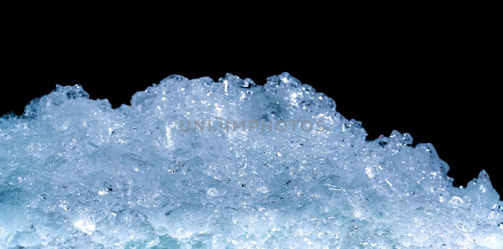 Pile of crushed ice cubes on dark background with copy space. Crushed ice cubes foreground for beverages. by Fahroni