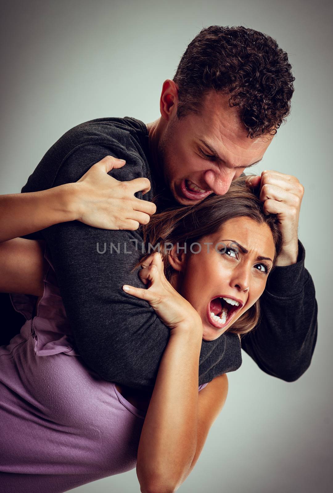 Angry aggressive husband trying to hit and choking his wife.