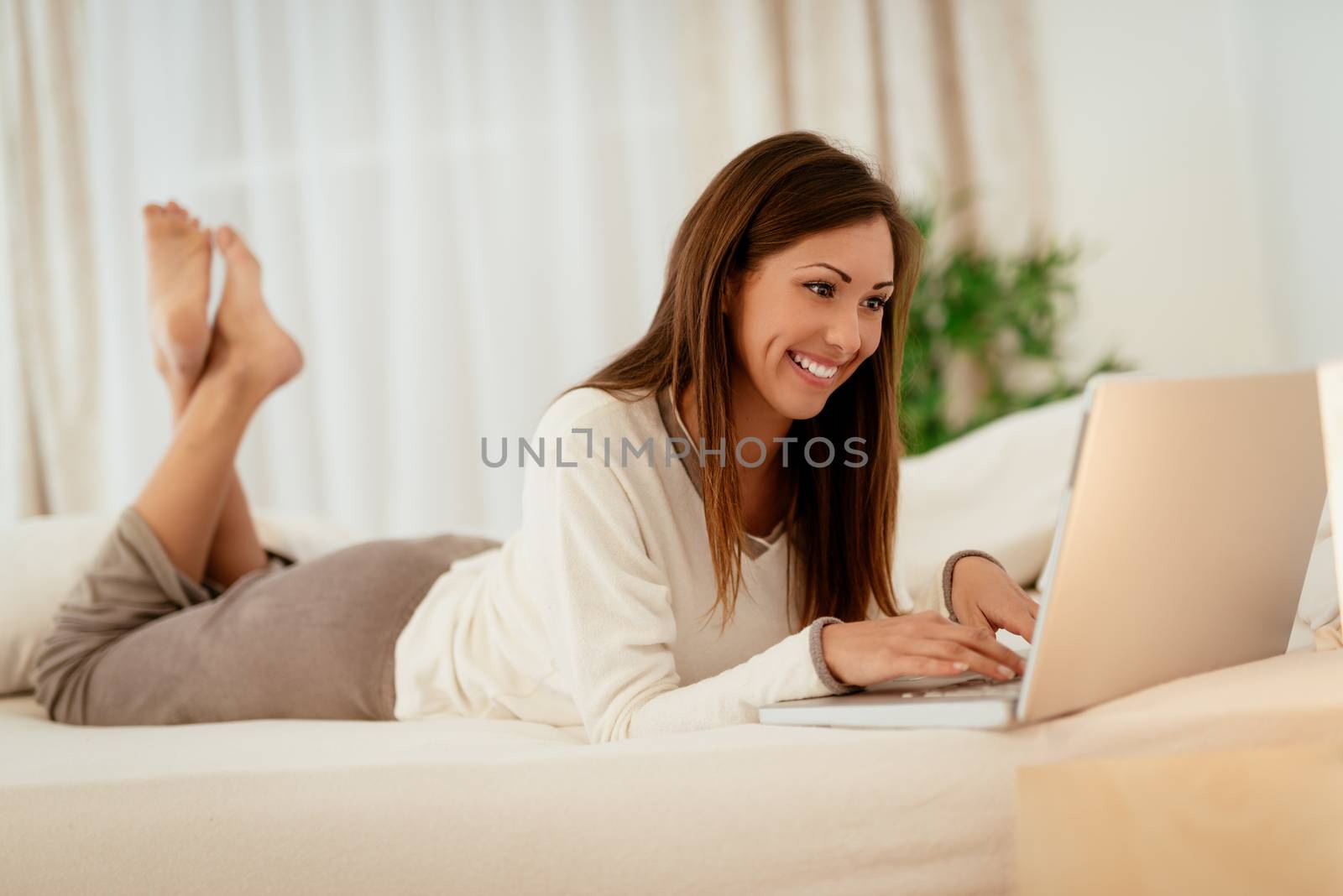 Woman Using Laptop In Bed by MilanMarkovic78