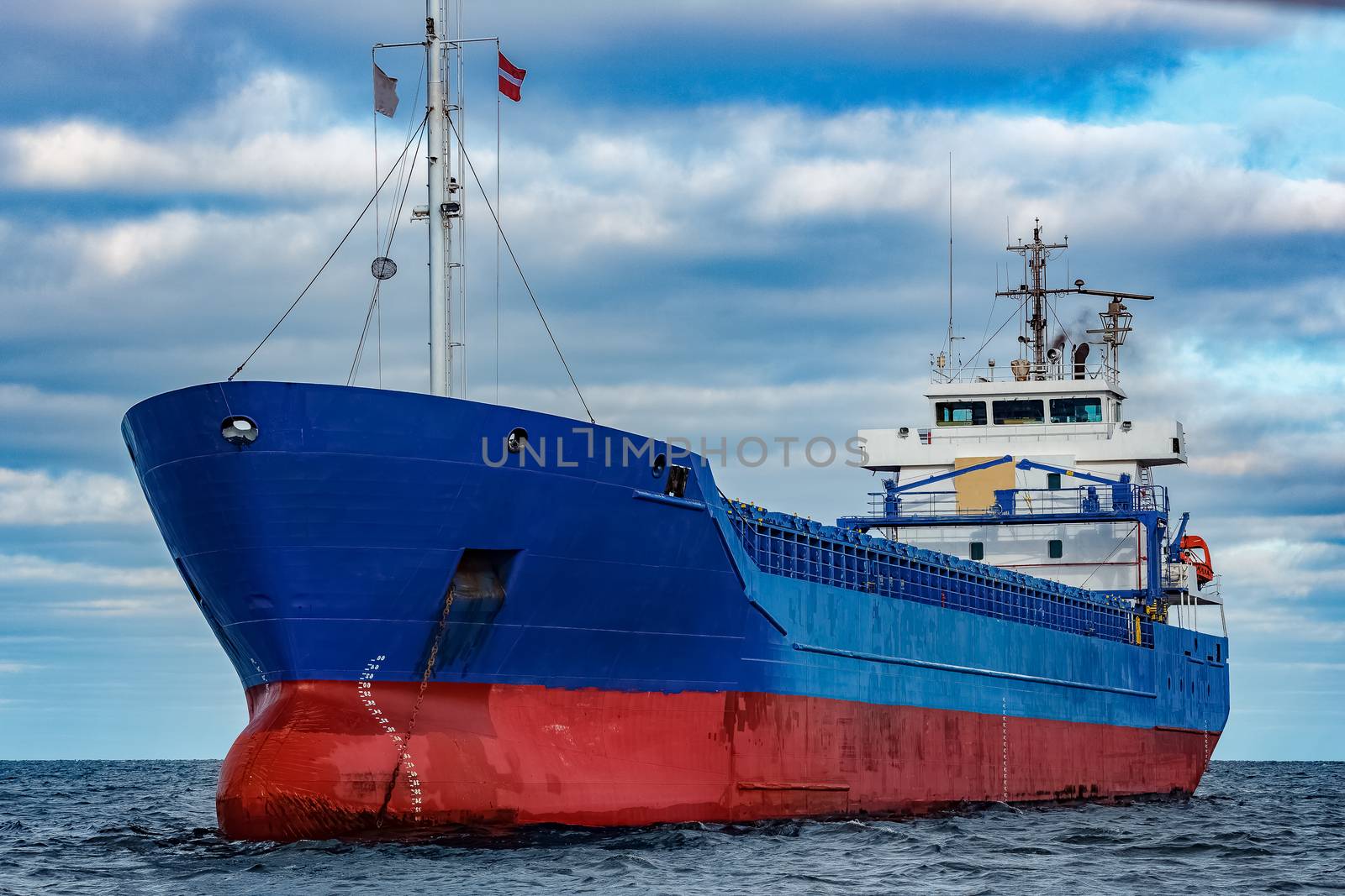 Blue cargo ship moored in still Baltic sea water