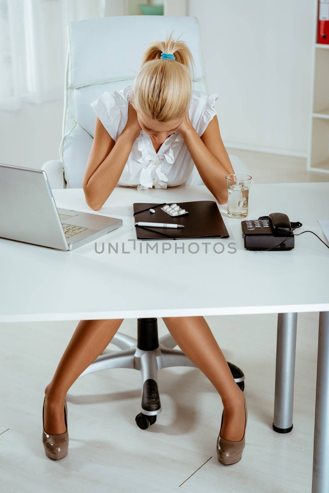 Young stressed business woman holding hands on the neck with a pained expression on her face.