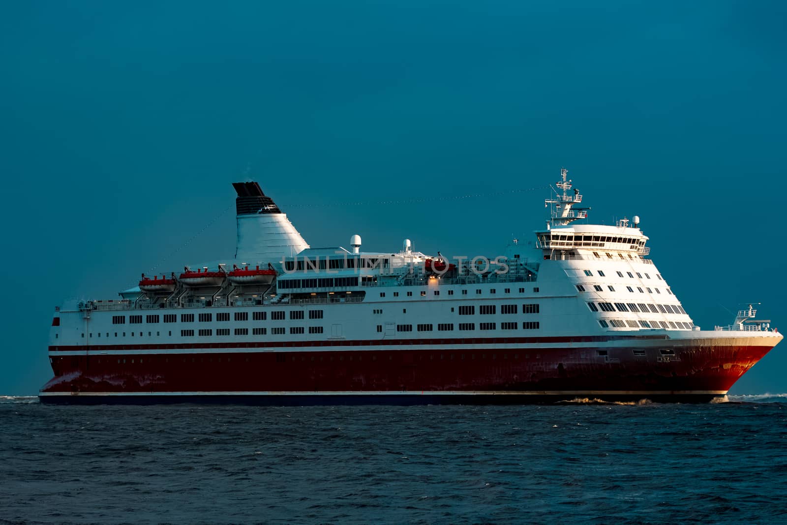 Red cruise liner. Passenger ship sailing from the sea in the morning