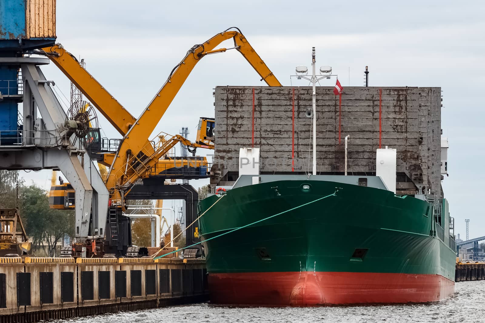 Green cargo ship loading in the port of Riga, Europe