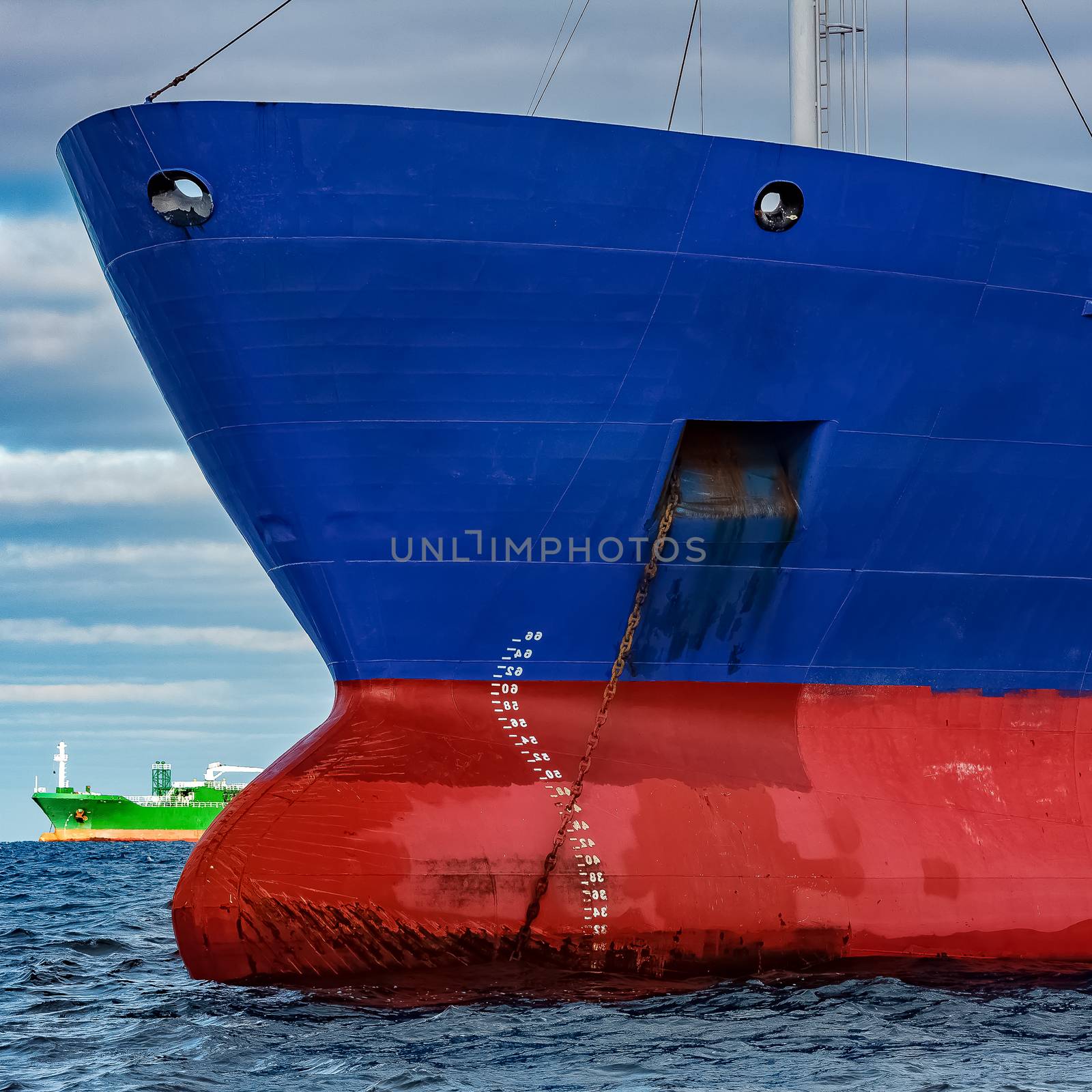 Blue cargo ship moored in still Baltic sea water