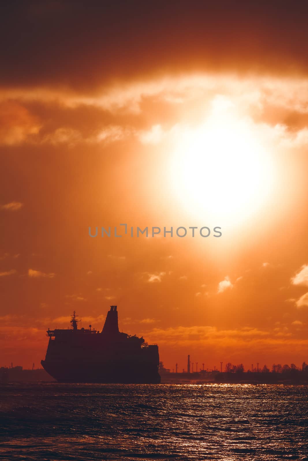 Hot orange winter sunrise against the cargo port