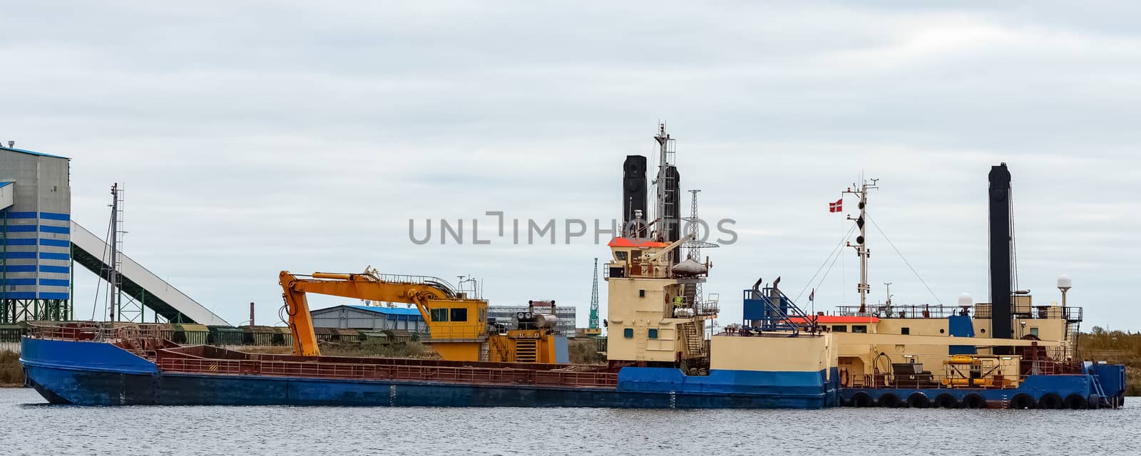 Blue cargo ship loading in the port of Riga, Europe