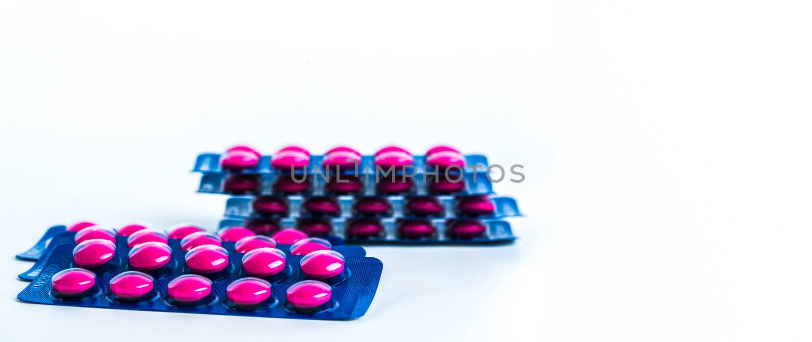 Ibuprofen in pink tablet pills pack in blue blister pack isolated on white background with copy space. Ibuprofen for relief pain, headache, high fever and anti-inflammatory. Painkiller tablets pills.