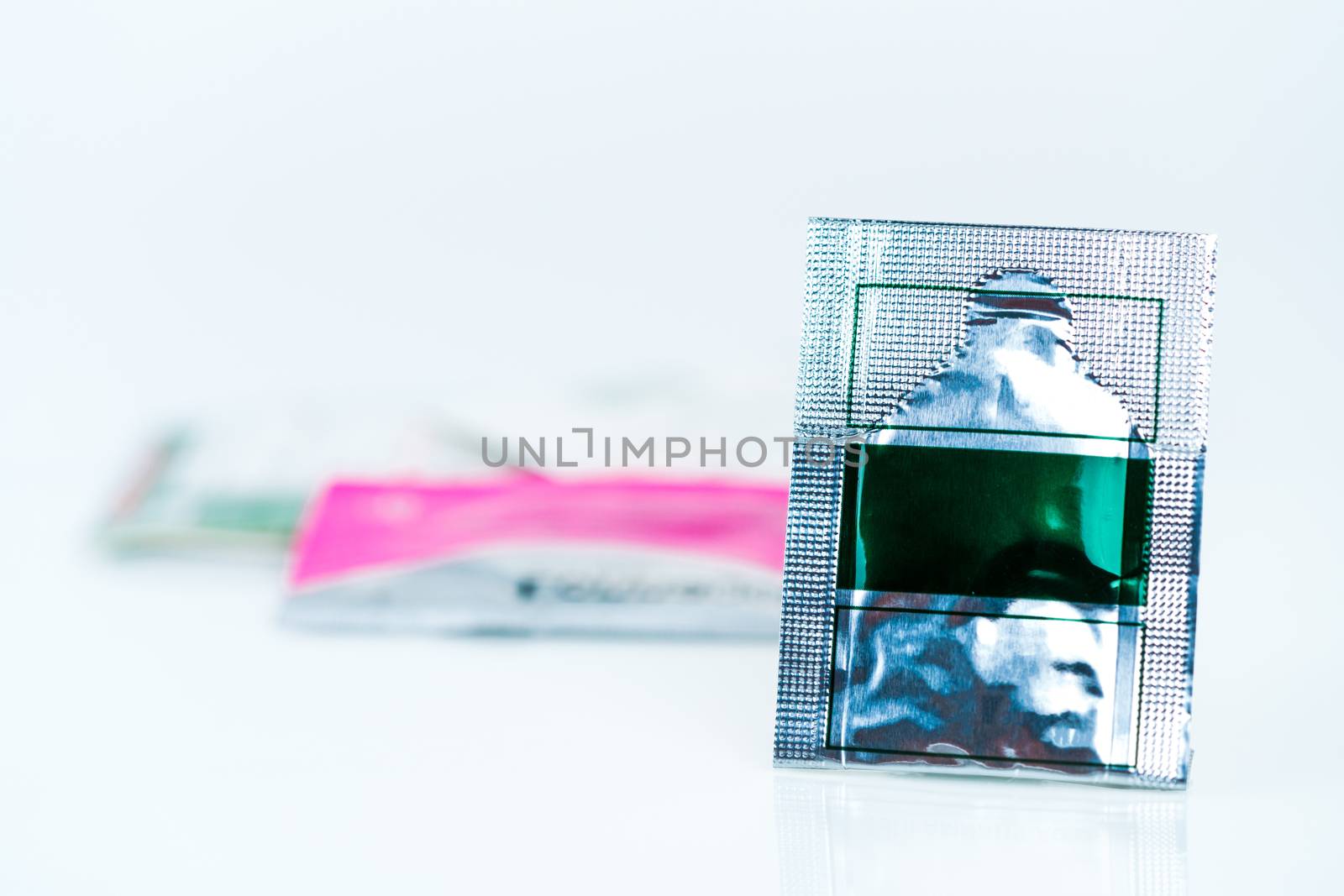Mild steroid oral paste in aluminium foil sachet on blur background of sachets. Anti-inflammatory for oral mucous membrane, relief oral tenderness, pain, and ulceration. Aphthous ulcer or mouth ulcers
