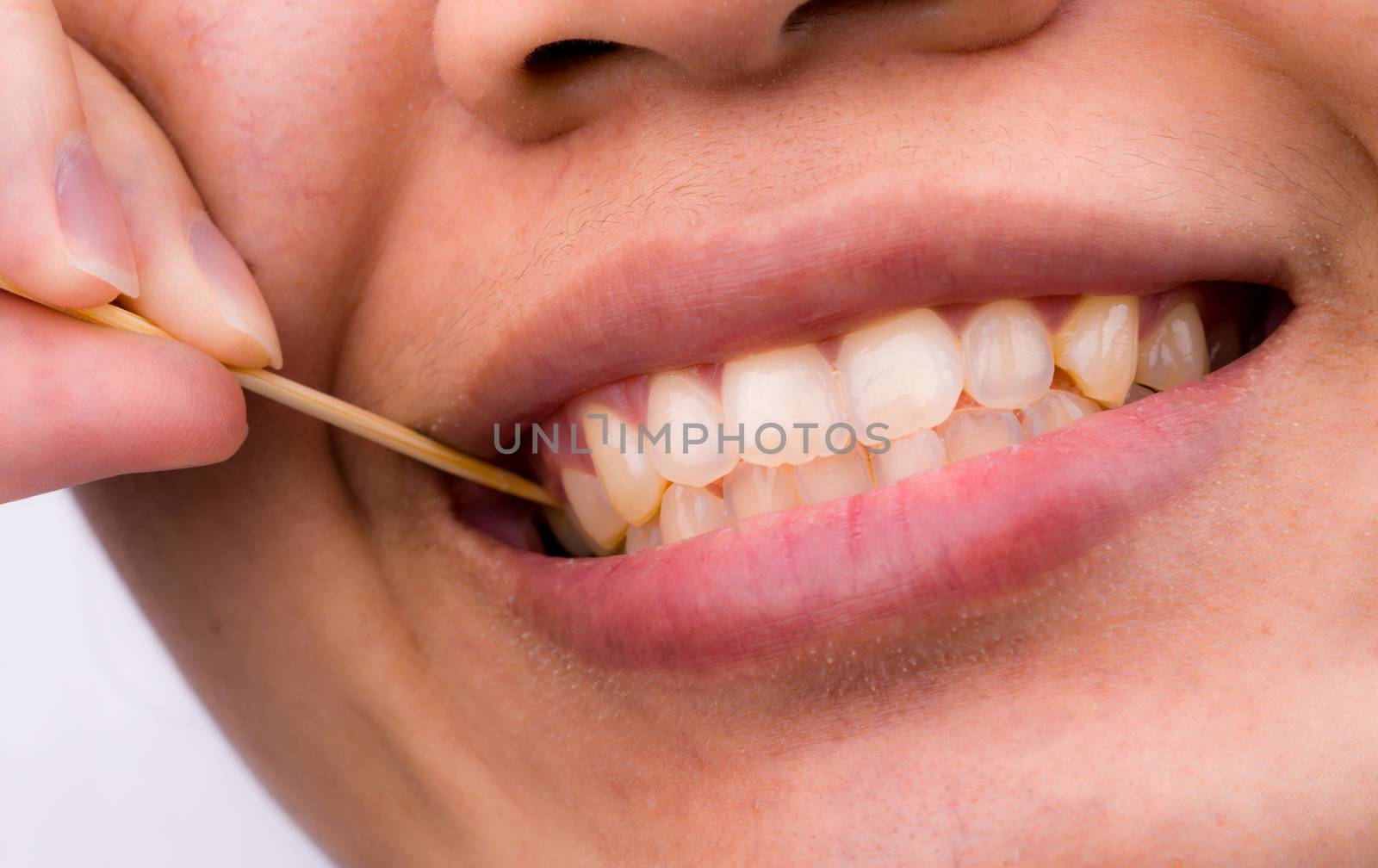 Asian woman clean her teeth from food stuck her teeth with bamboo wood toothpick after breakfast, lunch, dinner. Personal dental care with Asian style. Dental health and bad breath problem concept.