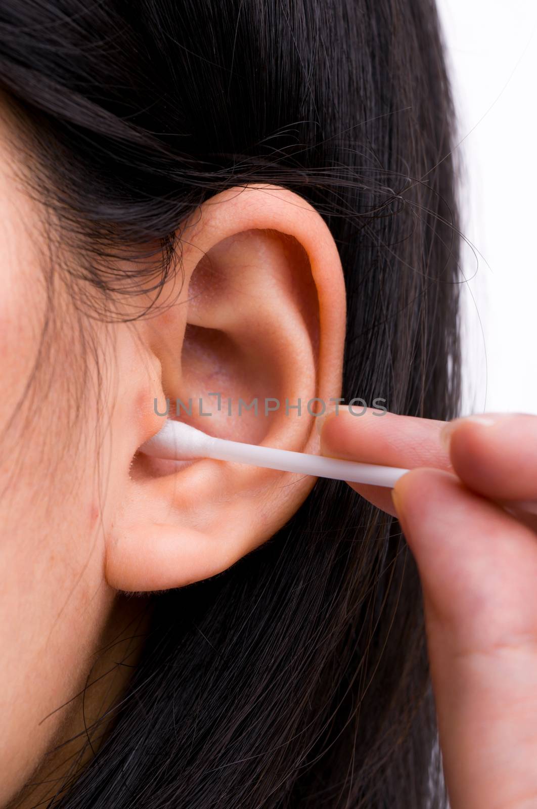 Woman with black hairs is cleaning her ears with white cotton bud. Personal hygiene concept. by Fahroni