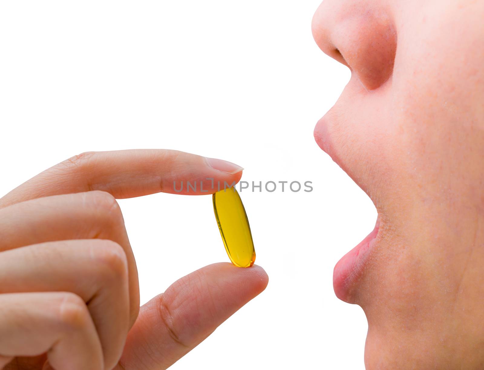 Young woman hand hold fish oil capsule near open mouth. Woman taking omega-3 pills. Vitamins and supplements concept. by Fahroni