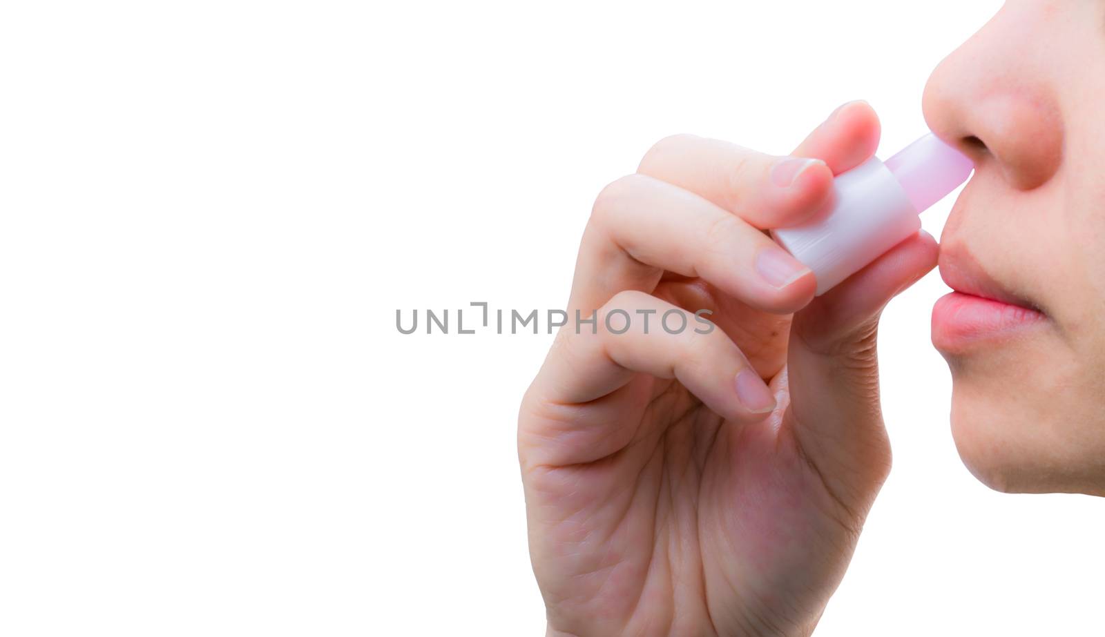 Asian Woman's hand hold nasal inhaler and inhale through nostril to relief nasal congestion for breathing more comfortable and help relieve the symptoms of motion sickness, relief vertigo, feel faint. by Fahroni