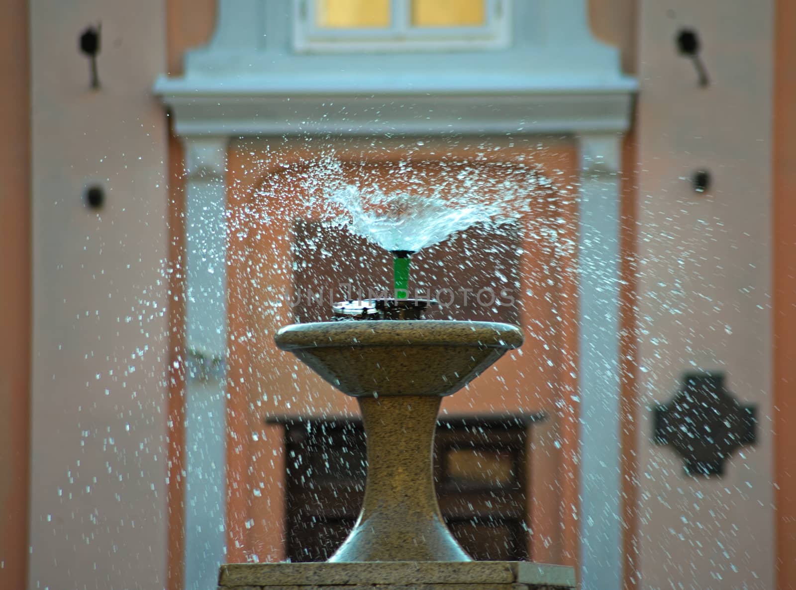 droplets dispersing from a fountain and buildings in background by sheriffkule