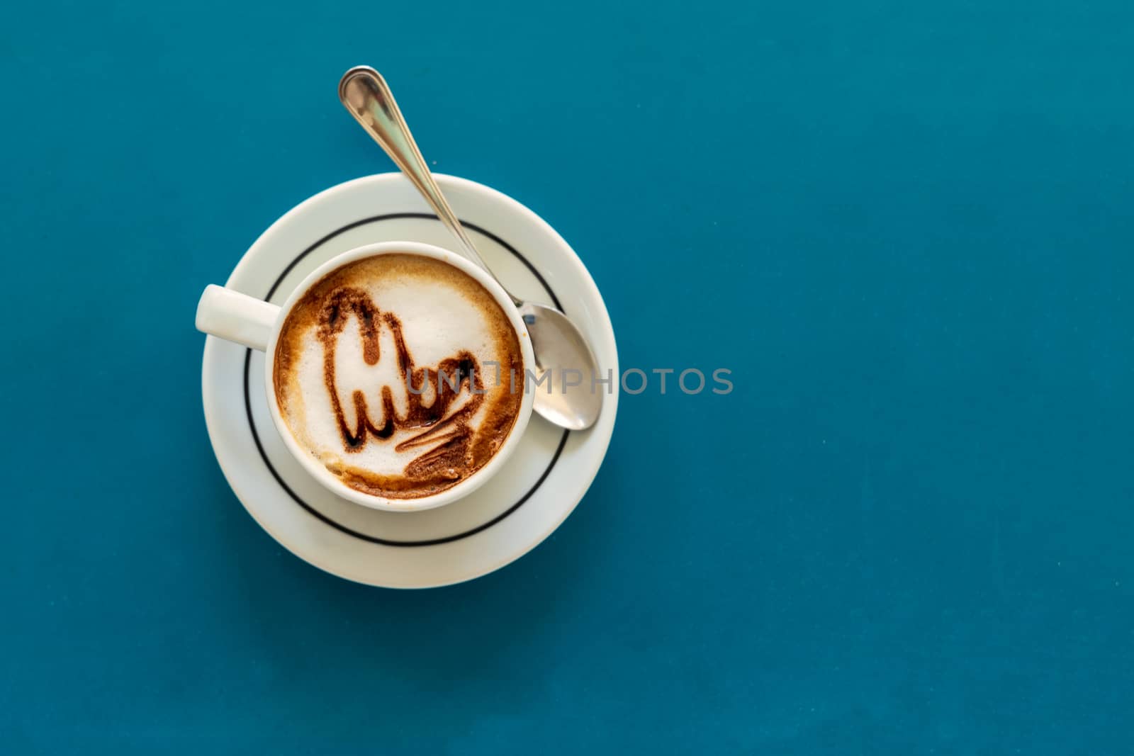Cappuccino on a cup with foam and above the foam the inscription Cuba on a turquoise background