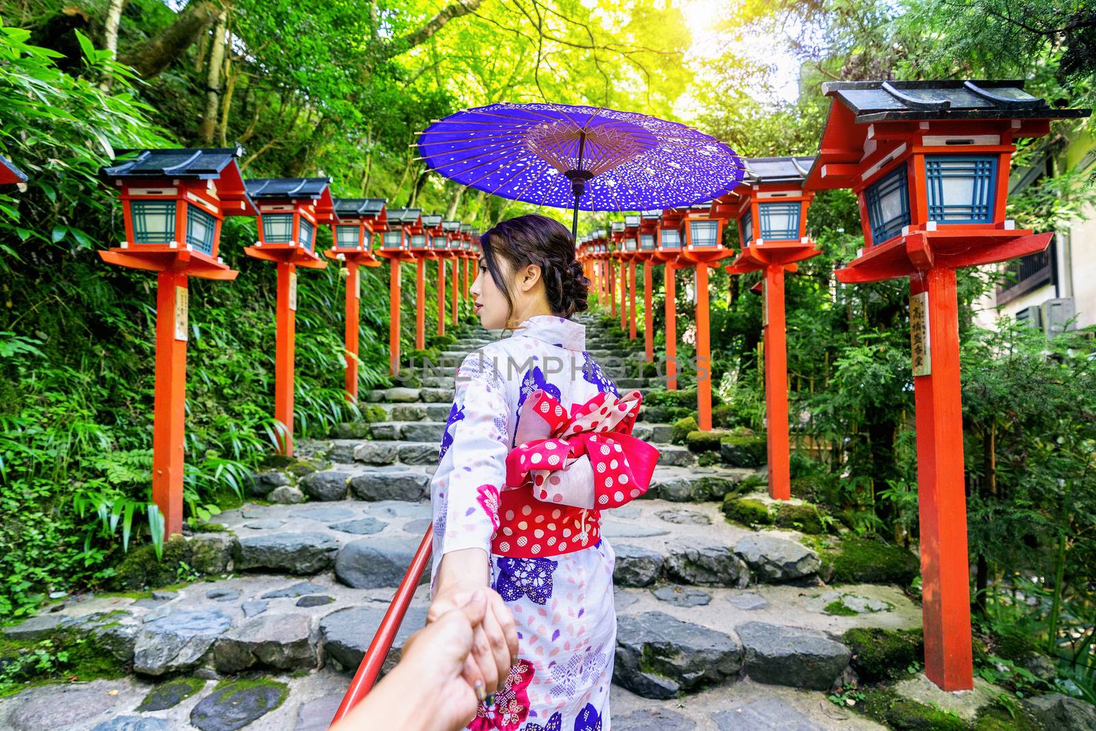 woman wearing japanese traditional kimono holding man's hand and leading him to Kifune shrine, Kyoto in Japan. by gutarphotoghaphy