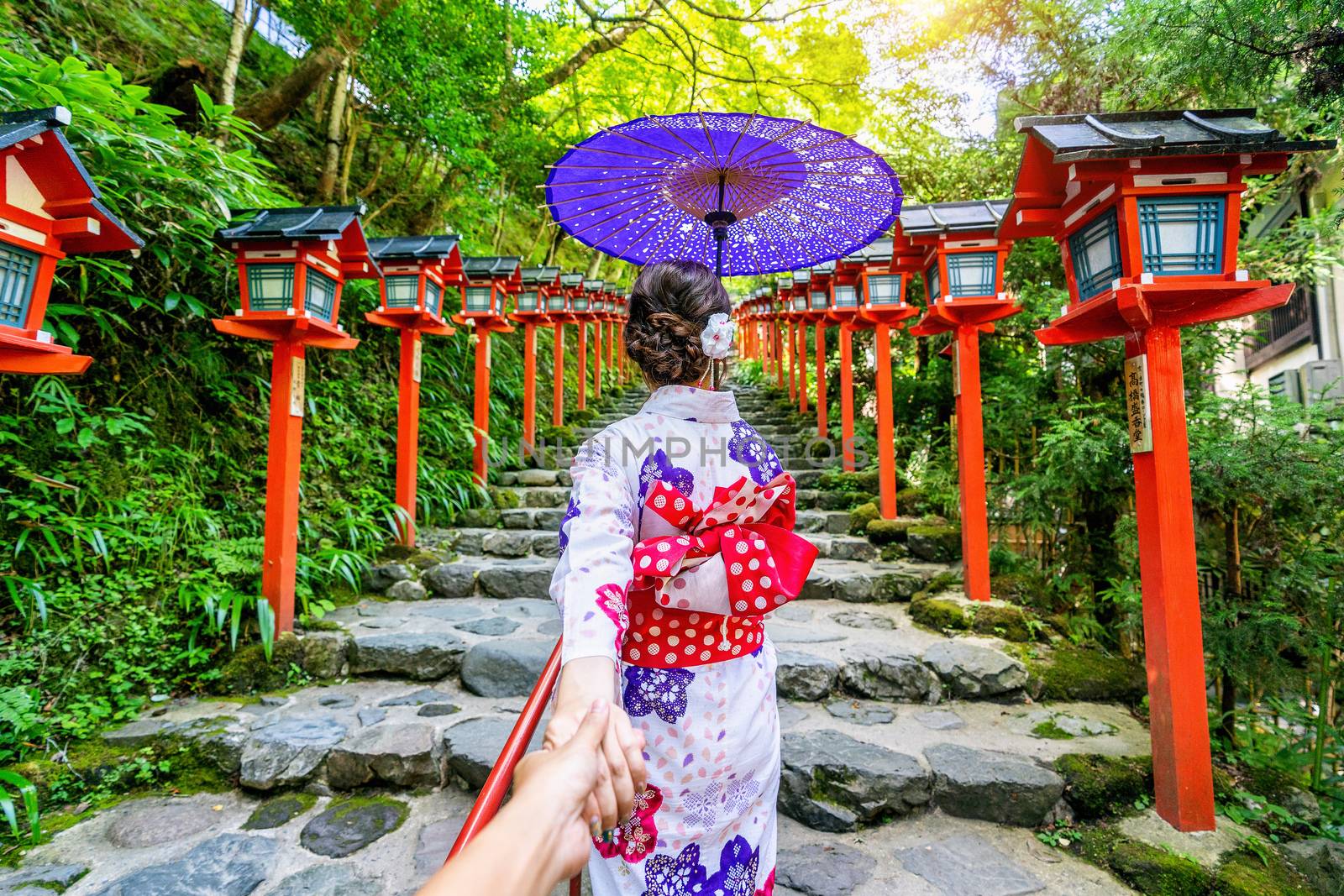 woman wearing japanese traditional kimono holding man's hand and leading him to Kifune shrine, Kyoto in Japan. by gutarphotoghaphy