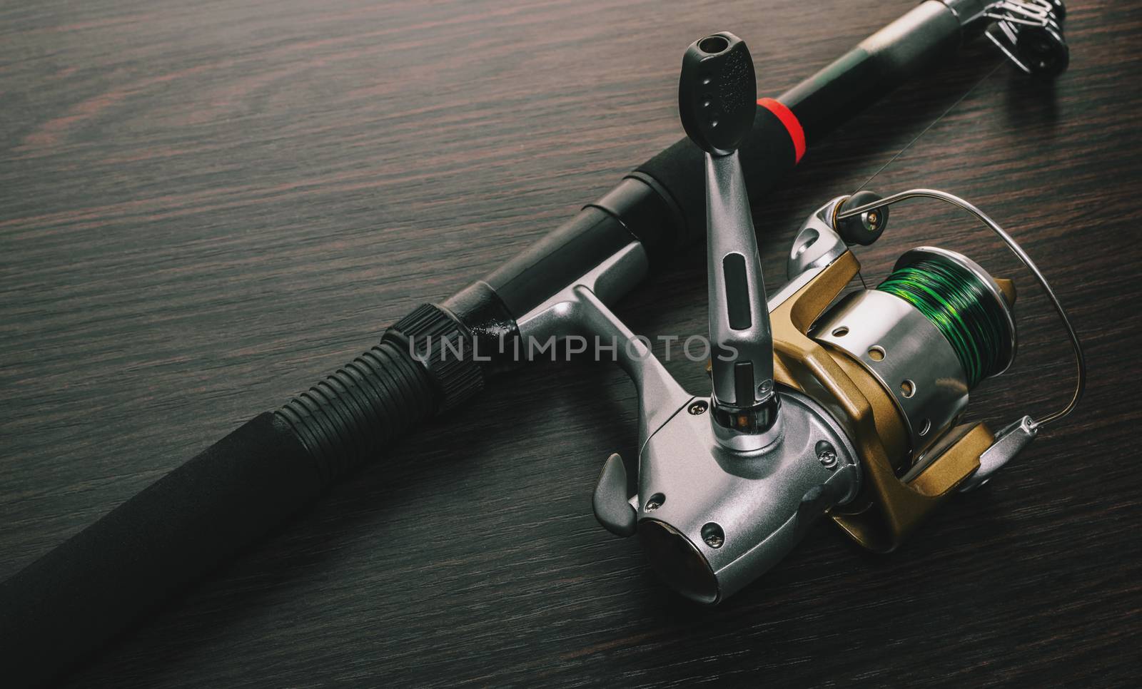 fishing rod with a coil on wooden background