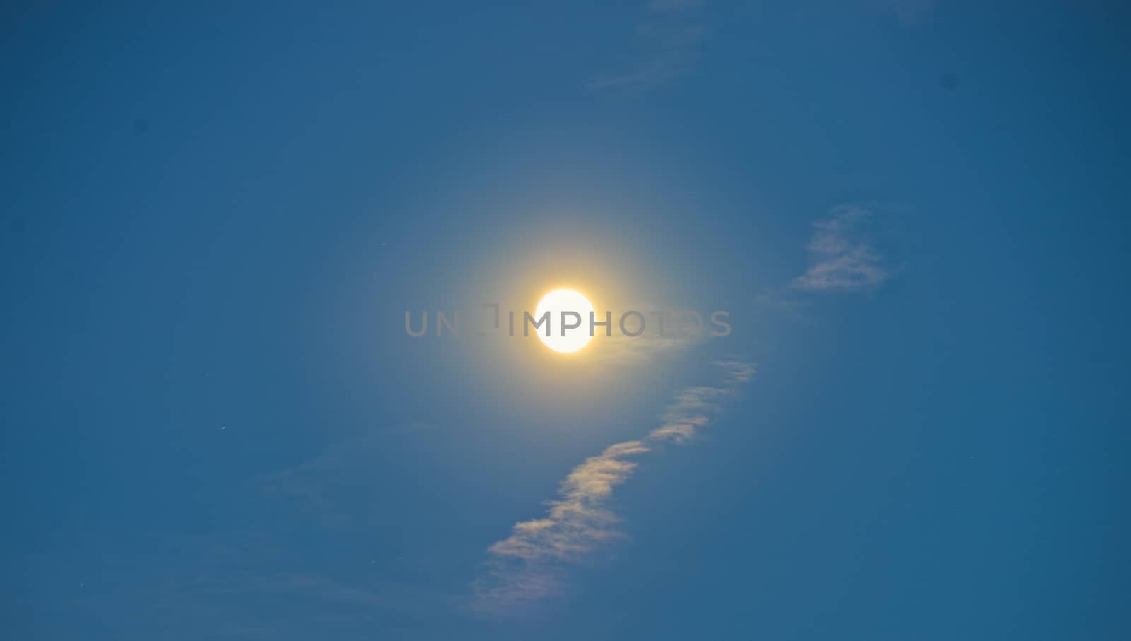 Full moon during sunset on blue sky by sheriffkule