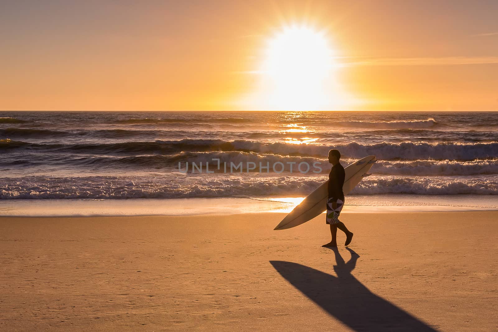 Surfer walking on the beach by homydesign