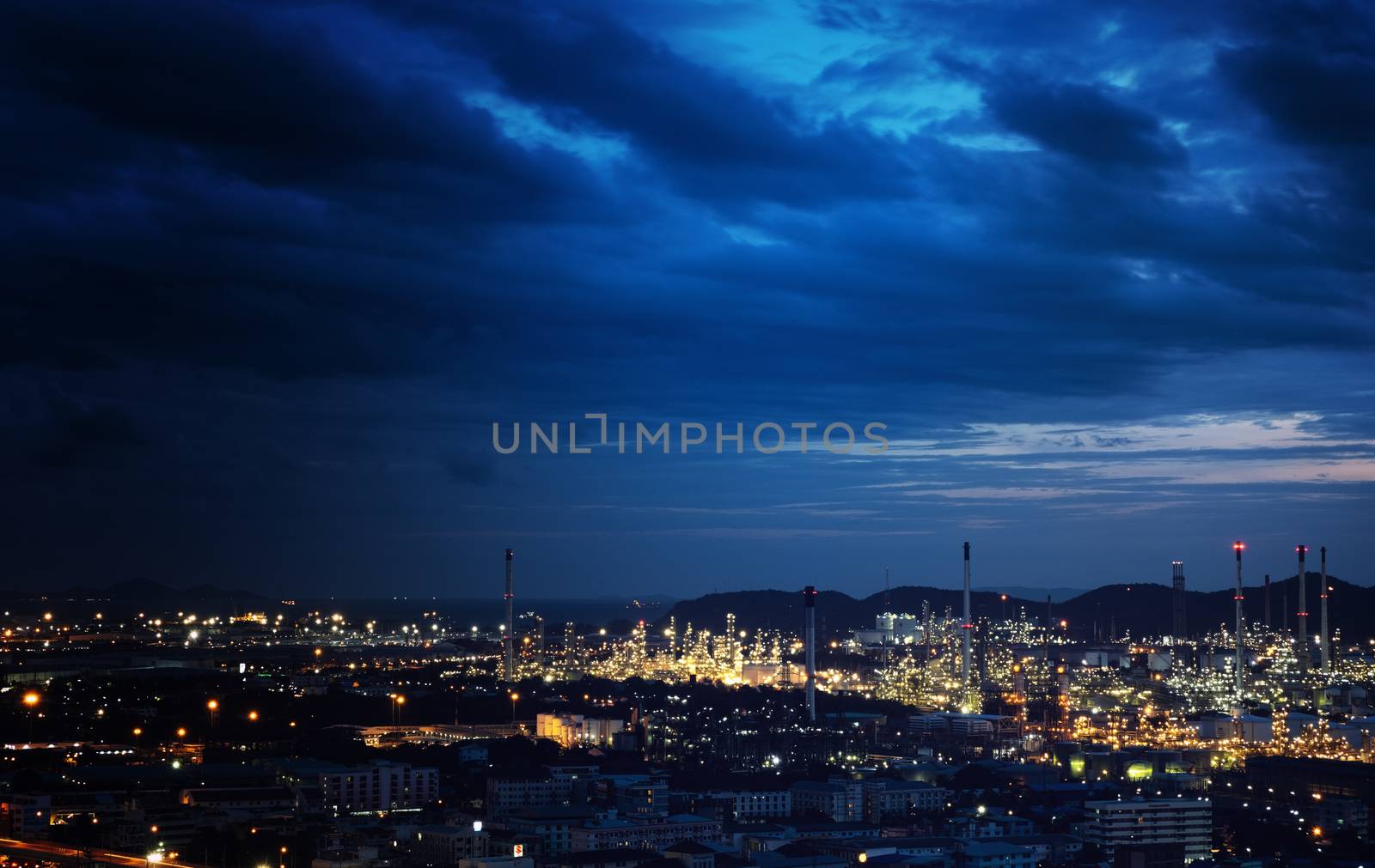 The industrial at the night. Beautiful light from the industrial and dark blue cloud.