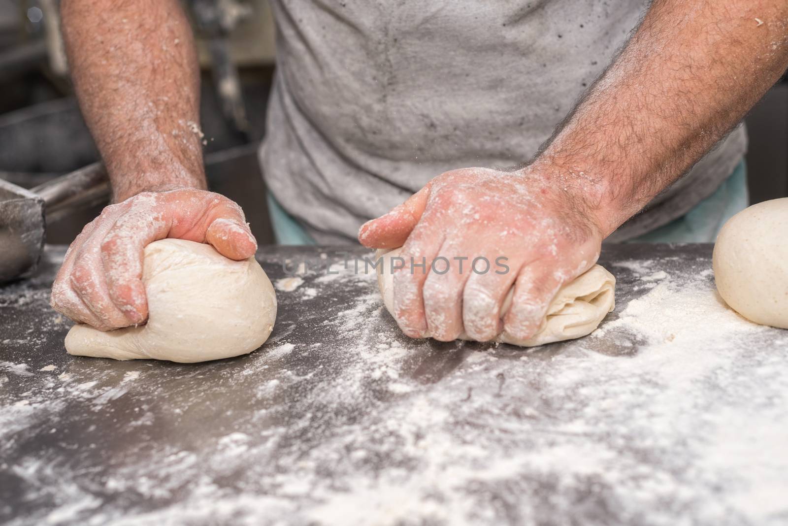 Baker hands kneading bread dough  by HERRAEZ