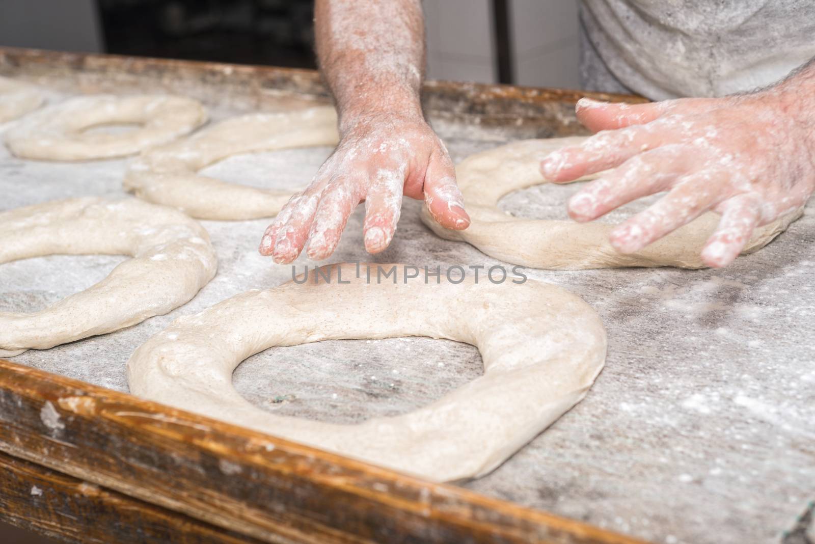 Baker hands kneading bread dough 