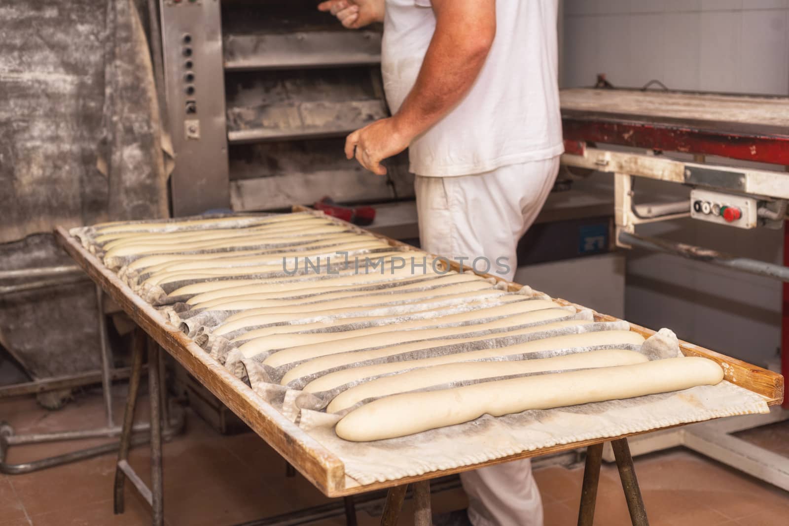 Baker preparing uncooked bread dough loaves ready to bake by HERRAEZ