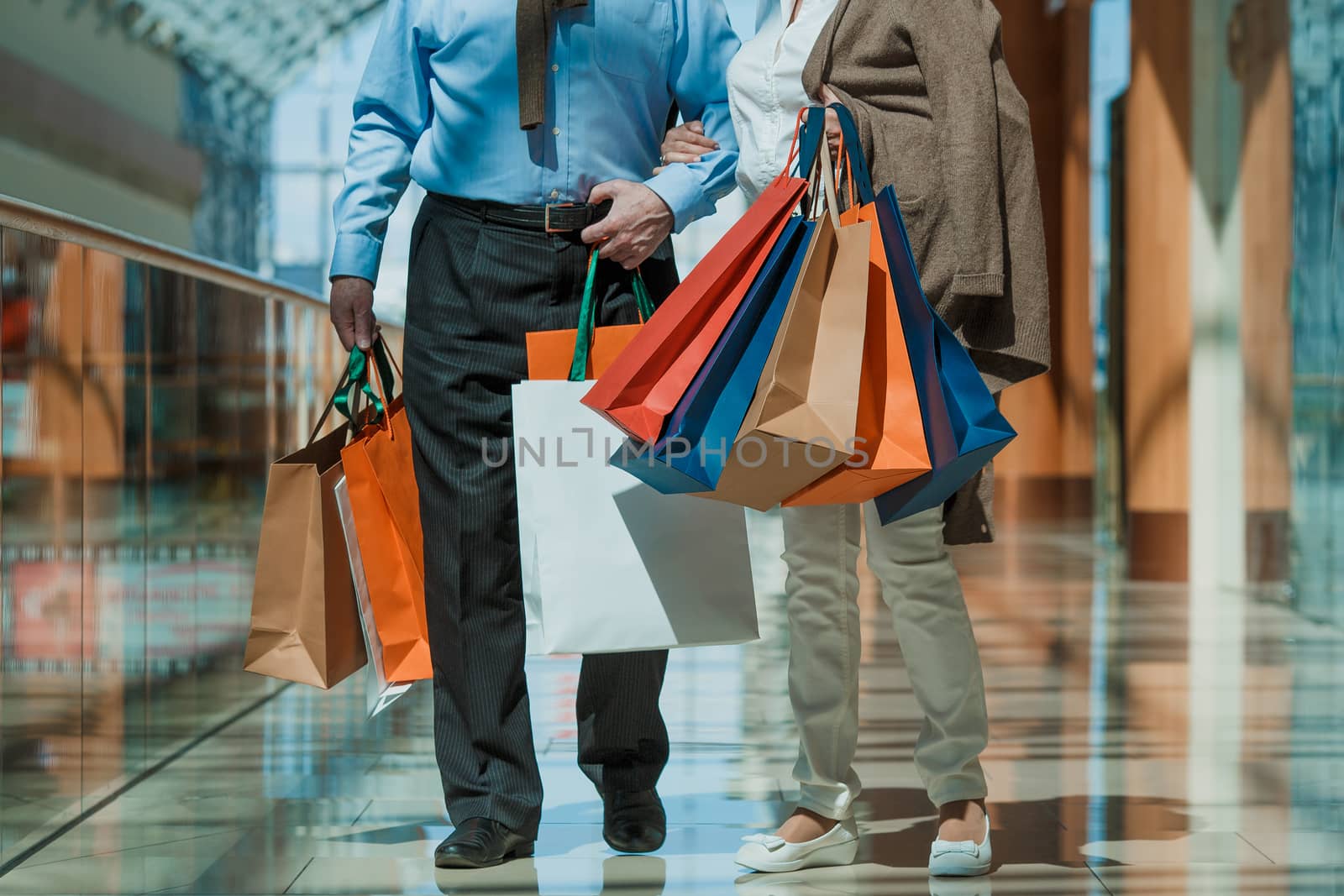 Adult senior couple with purchases in bags at shopping mall