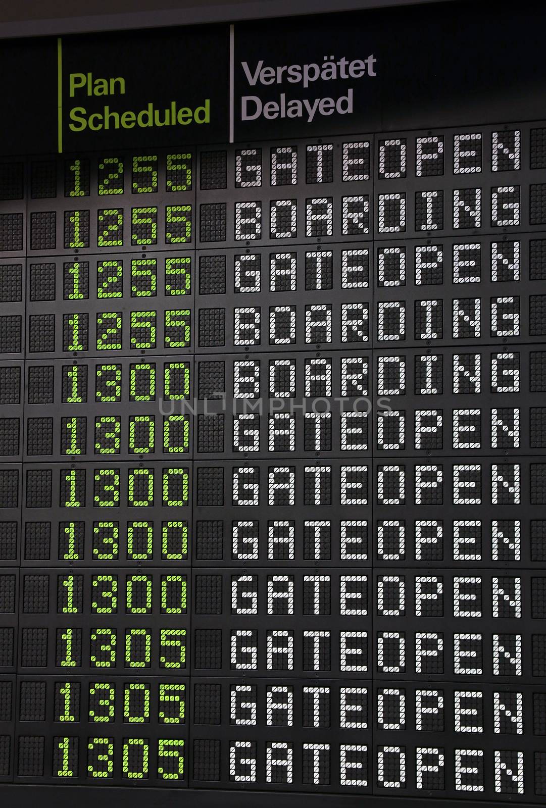 Flight information panel desk at airport, with time, boarding and gate open messages, close up, low angle view