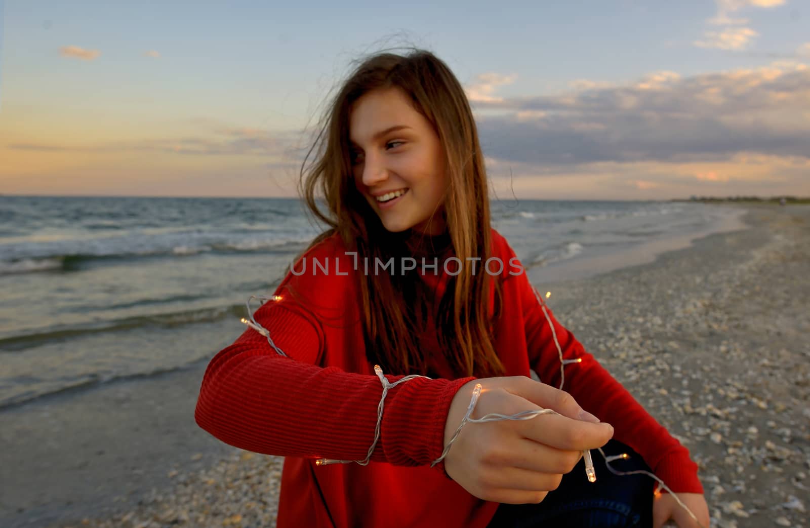 Teen girl with lights on summer beach