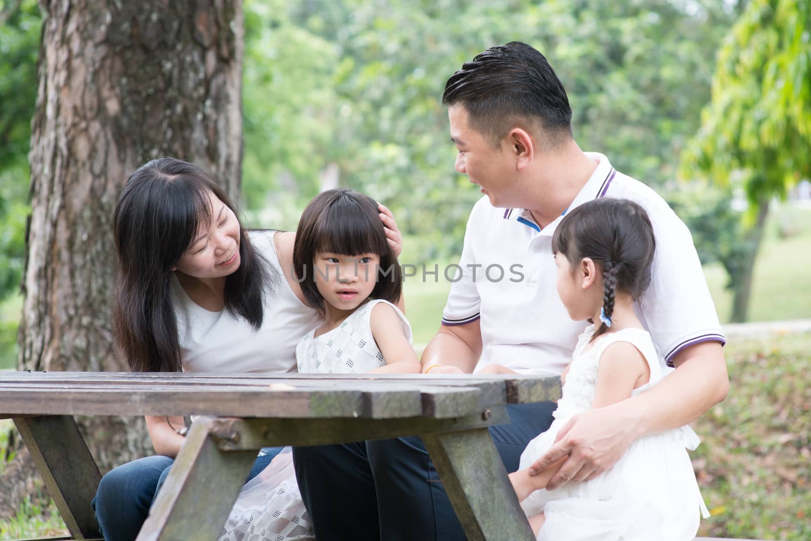 Asian family outdoors fun with empty table space.  by szefei