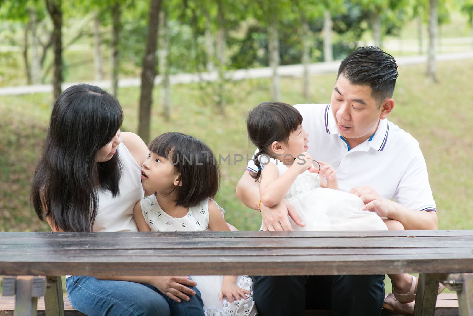 Asian family bonding outdoors with empty table space.  by szefei