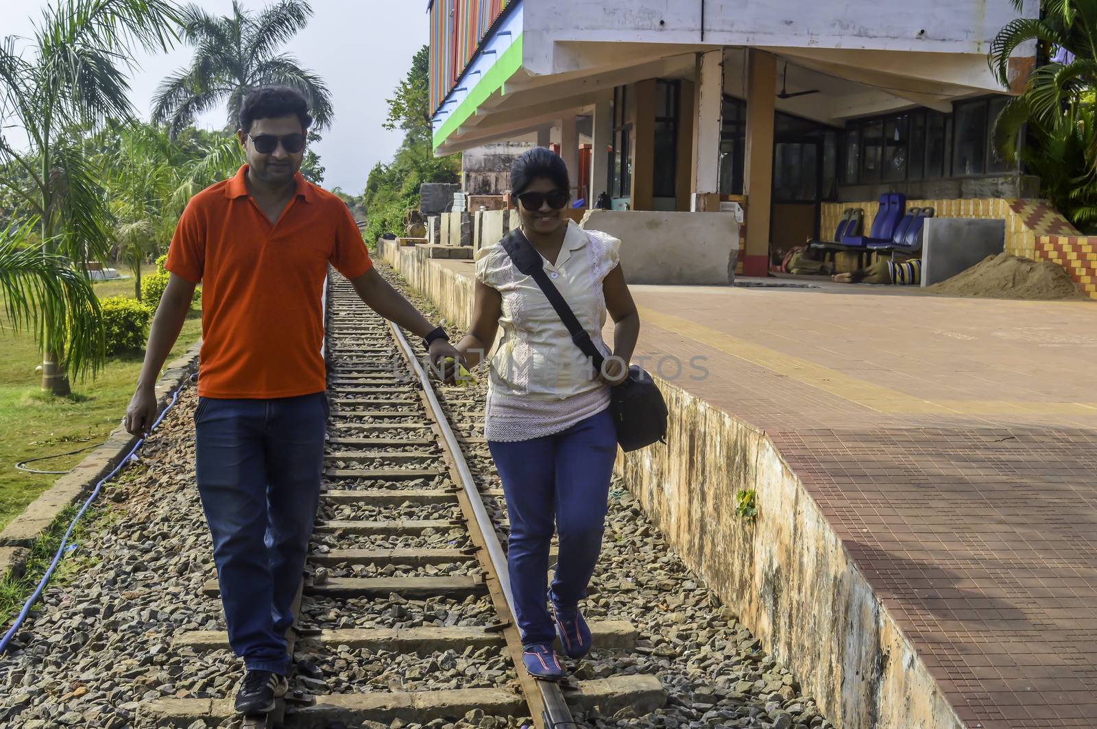 The young couple walking on a railway track. by sudiptabhowmick