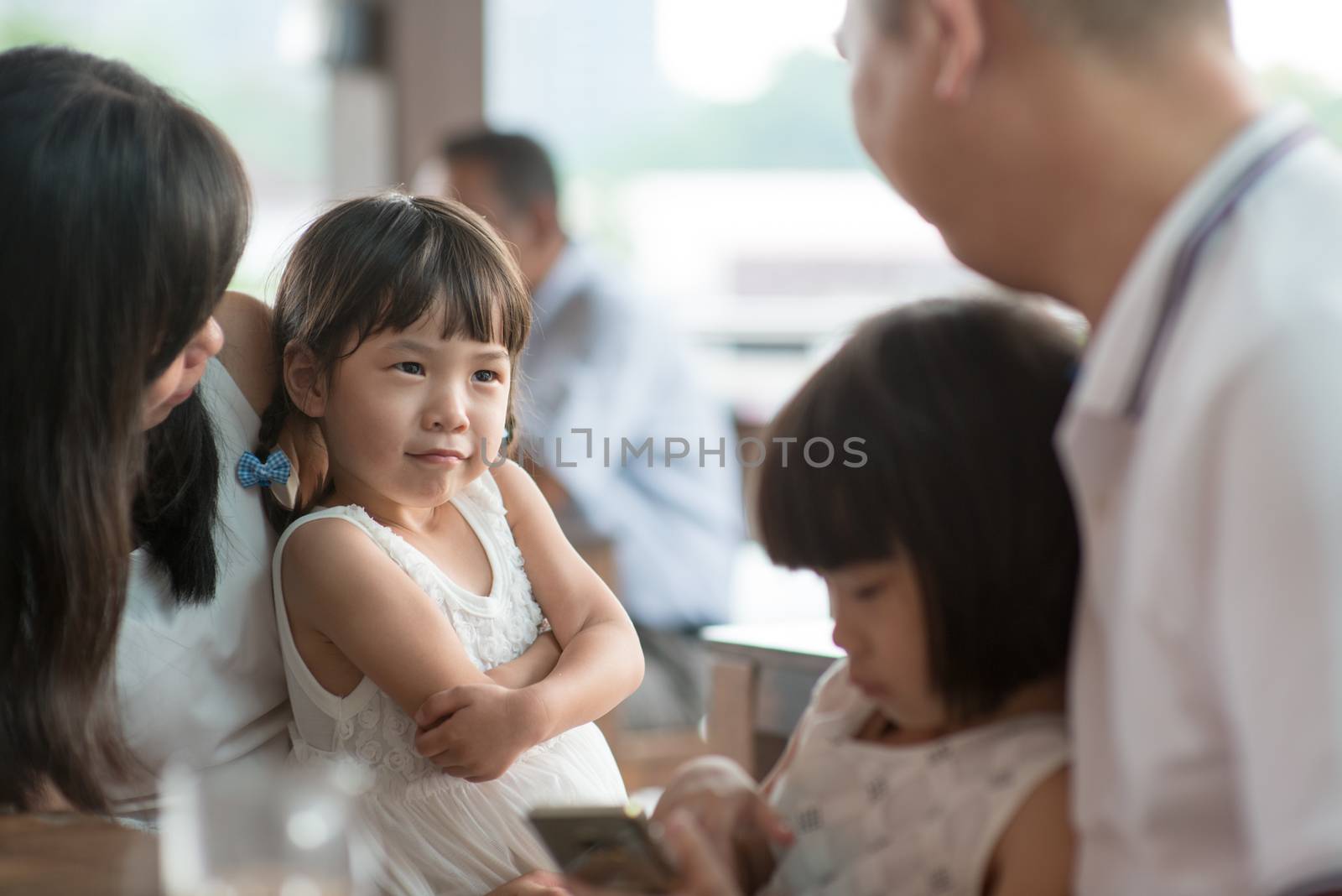 Candid shoot of people in cafeteria. Little girl with various face expression. Asian family outdoor lifestyle with natural light.