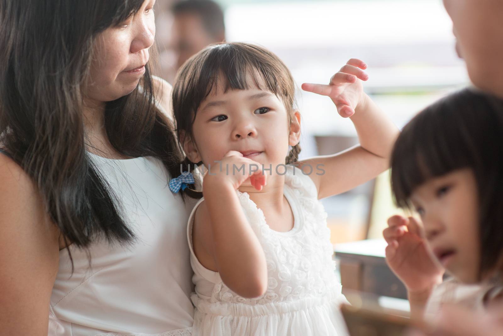 Candid shoot of people in cafeteria. Little girl with various face expression. Asian family outdoor lifestyle with natural light.