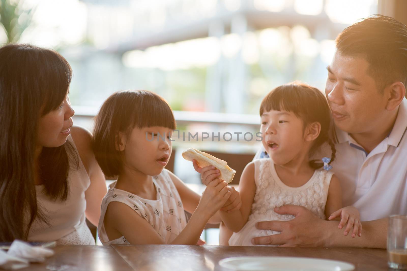 Asian family having meal at cafe by szefei