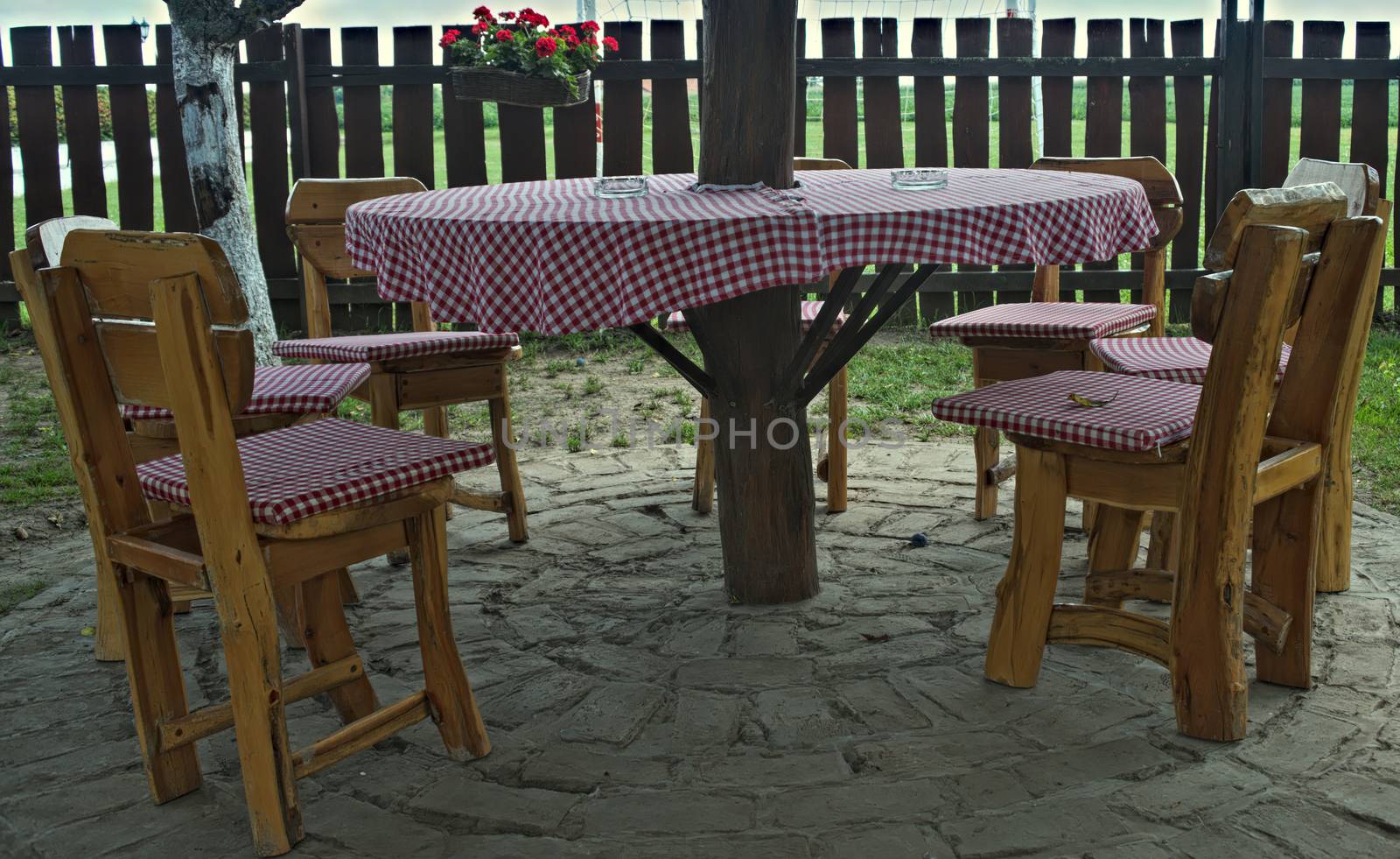 Vintage designed wooden table and chairs in front of fence in backyard