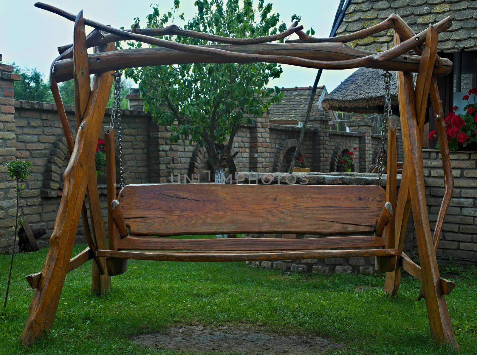 Retro designed old fashioned wooden hammock in backyard by sheriffkule