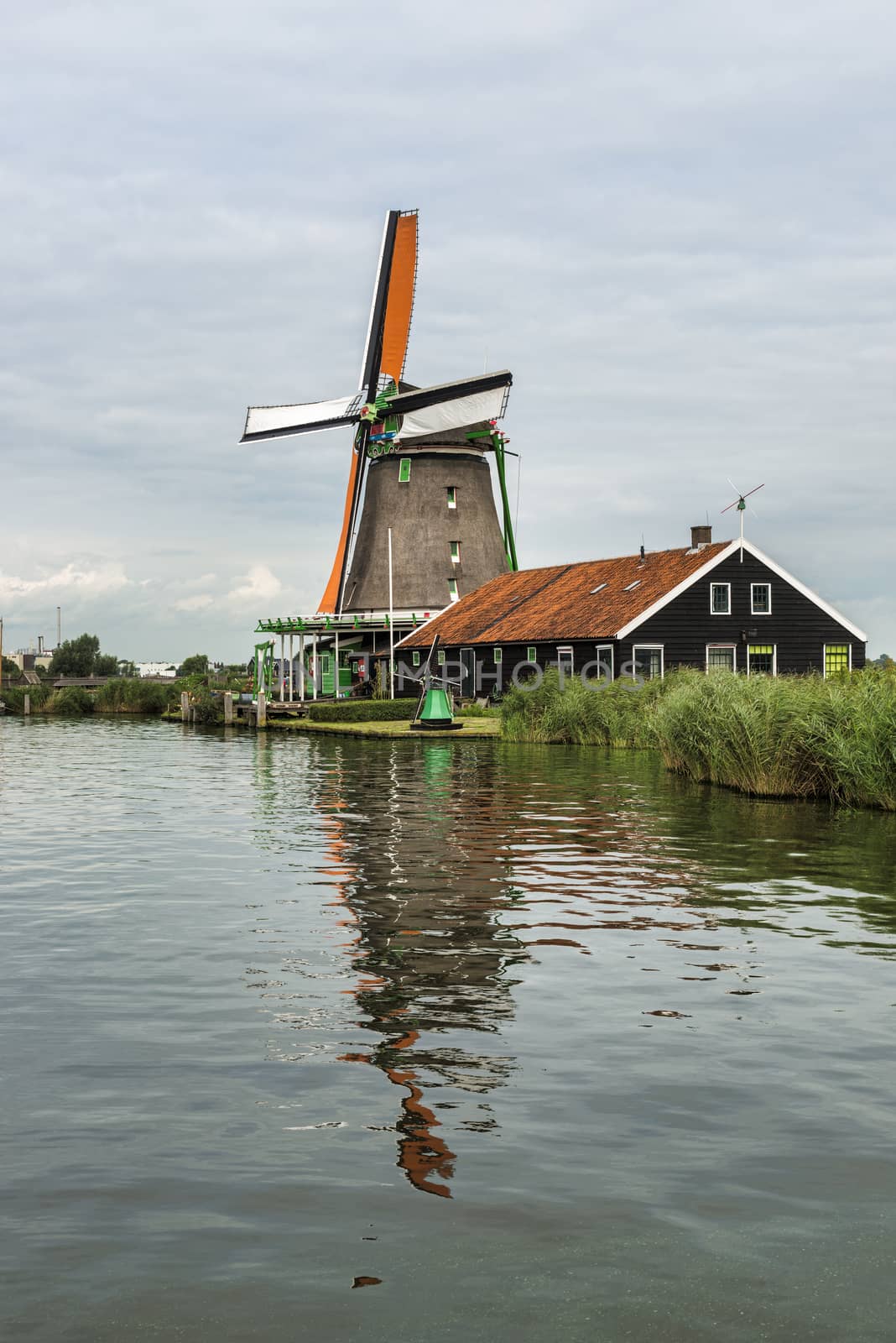 Authentic Zaandam mills on the water channel in Zaanstad village. Zaanse Schans Windmills and famous Netherlands canals, Europe.