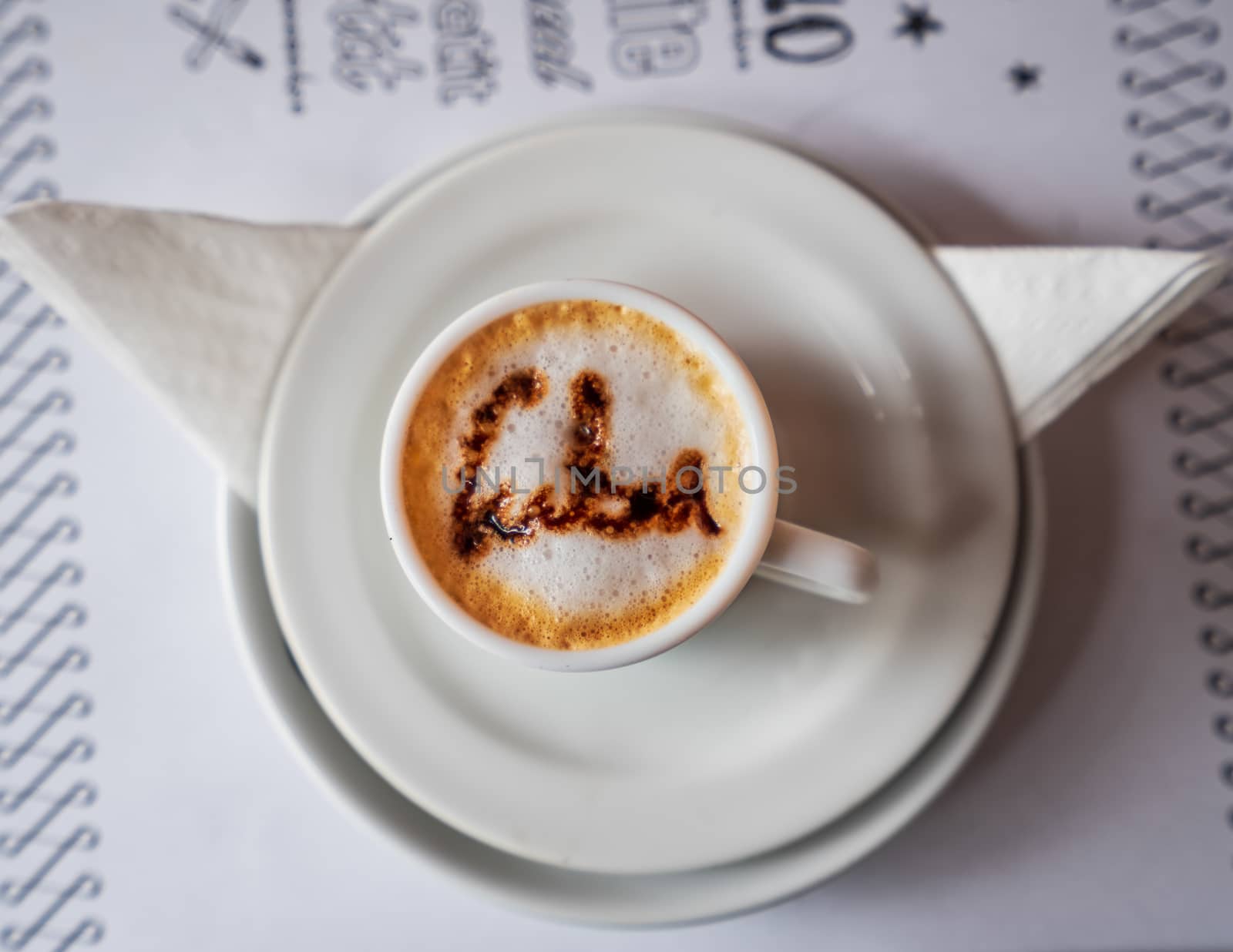 Coffee cup with foam and above the foam the inscription Cuba on a turquoise background