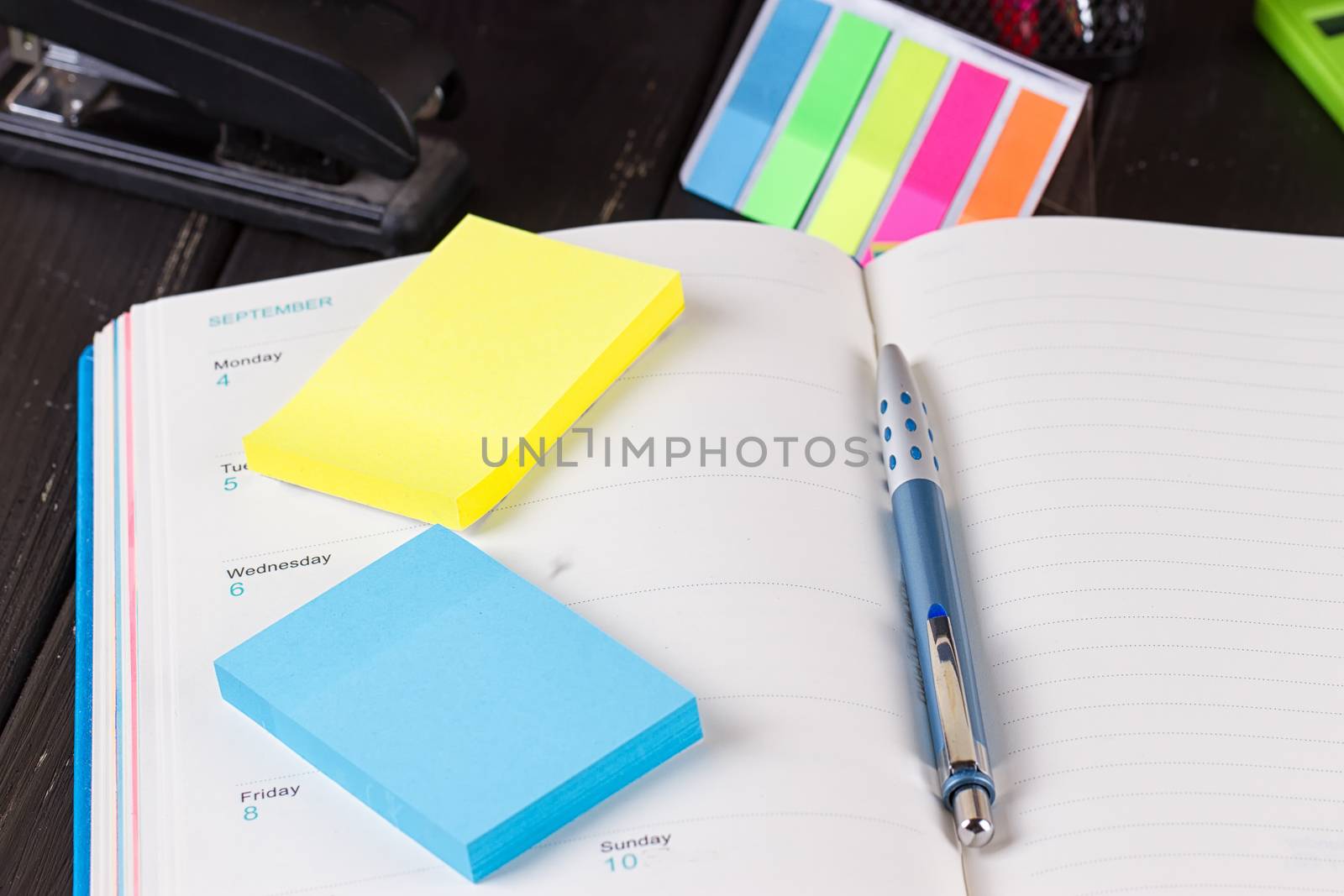 Open diary, pen on a black wooden background