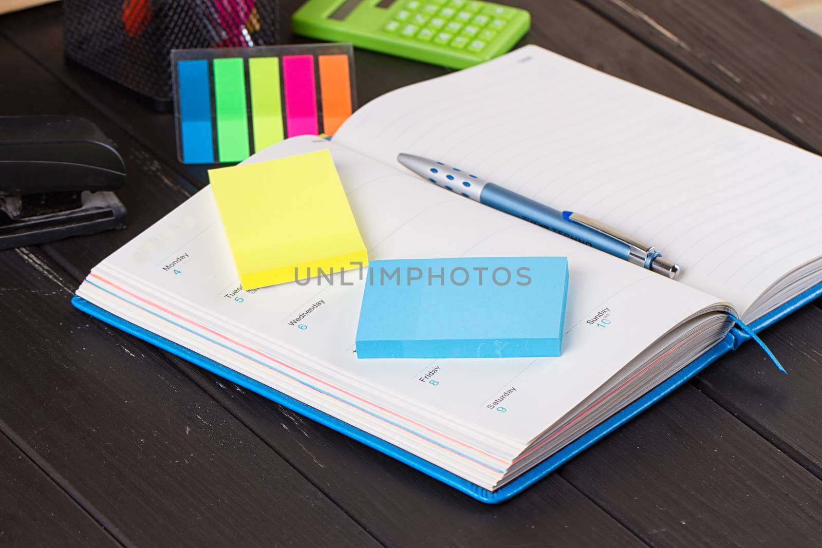 Open diary, pen on a black wooden background