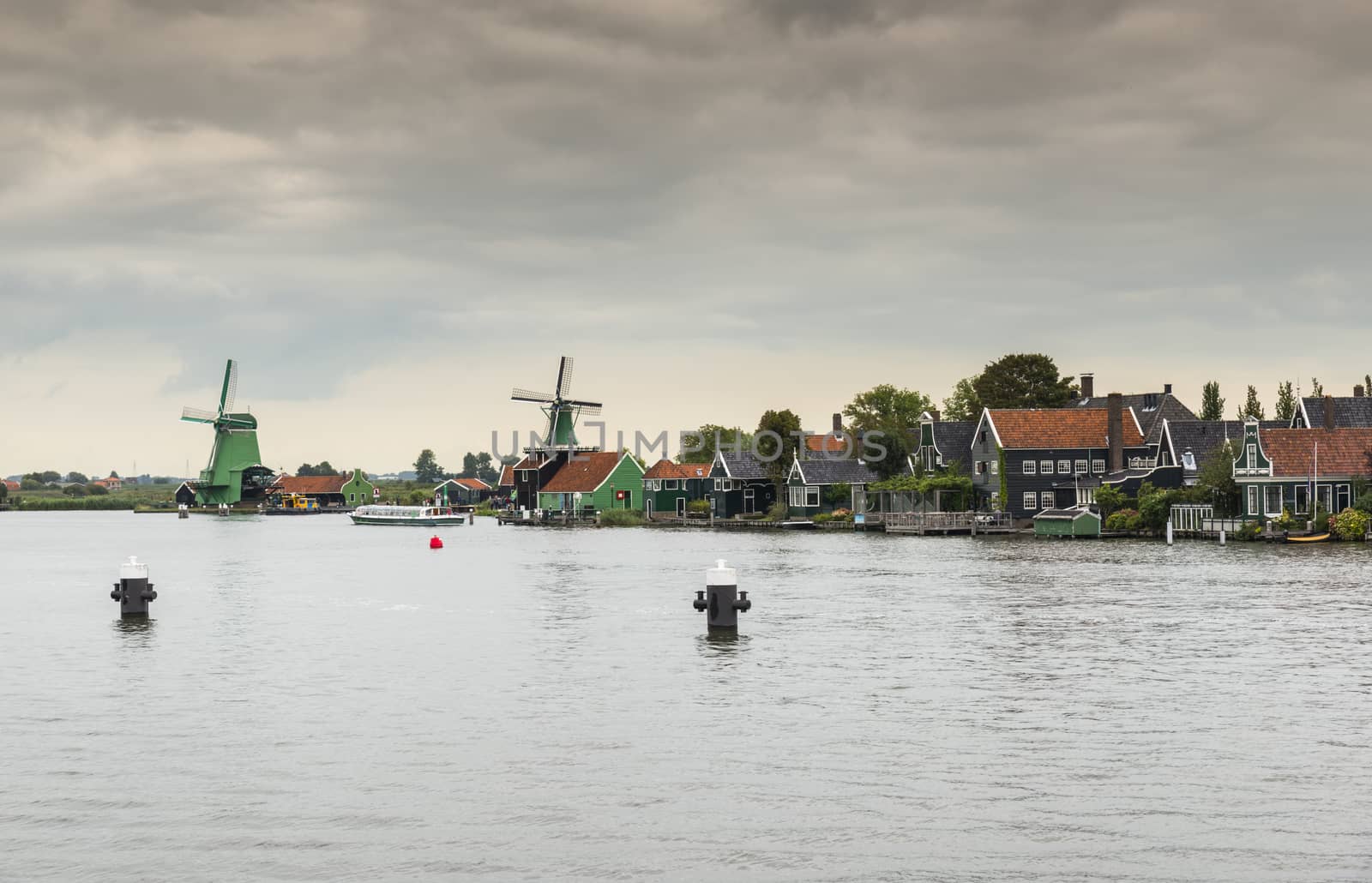 Authentic Zaandam mills on the water channel in Zaanstad village. Zaanse Schans Windmills and famous Netherlands canals, Europe.