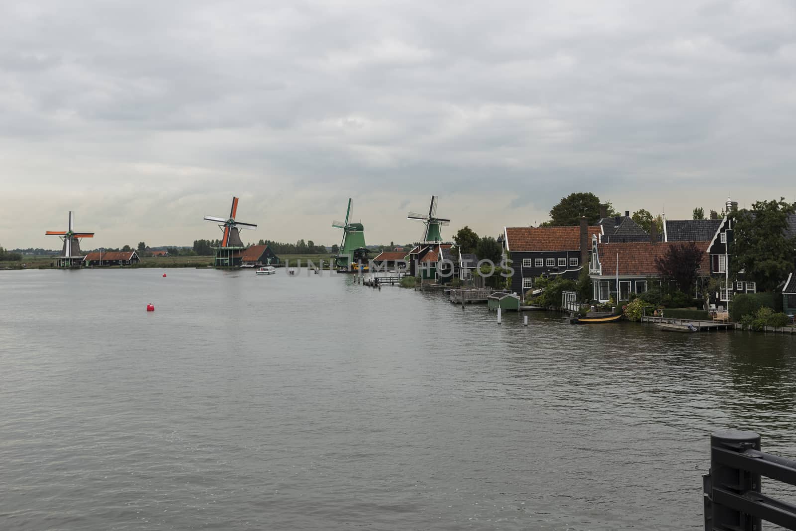 Authentic Zaandam mills on the water channel in Zaanstad village. Zaanse Schans Windmills and famous Netherlands canals, Europe.